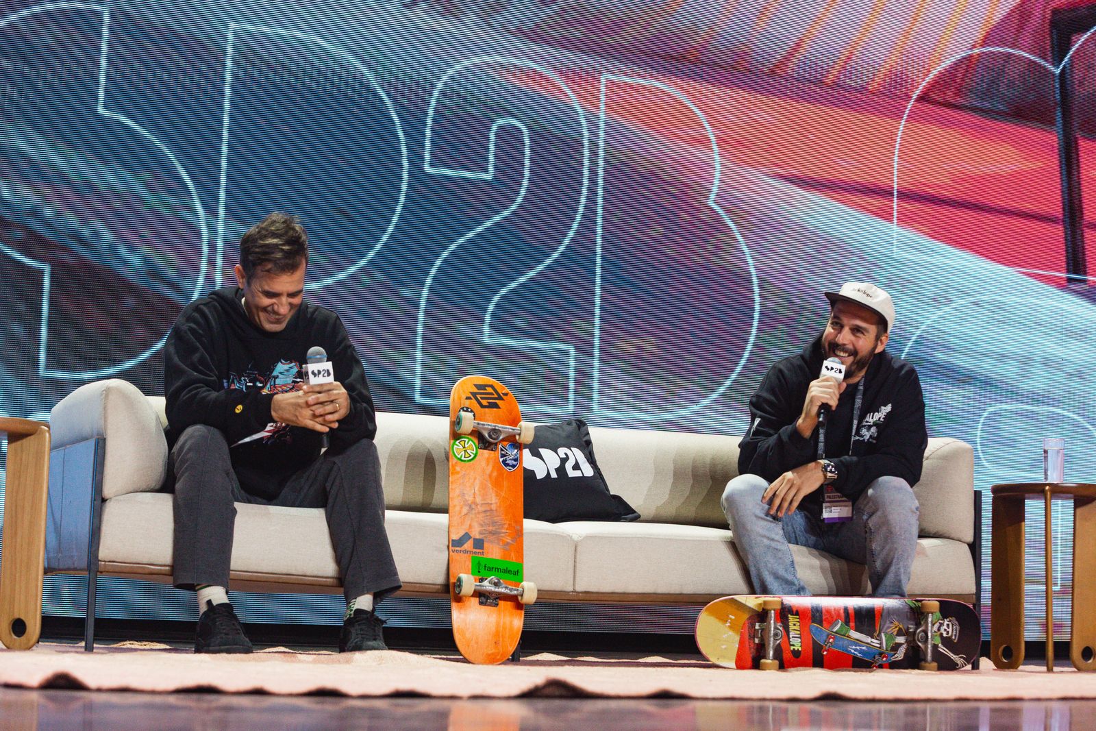 Micah and Bob Burnquist cracking up on the SP2B Beyond Business couch, skateboards at their feet