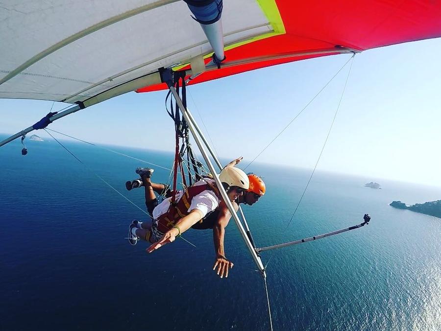 Micah tandem hang-gliding high above a blue sea